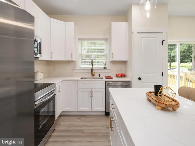 a kitchen with a sink stove top oven and refrigerator