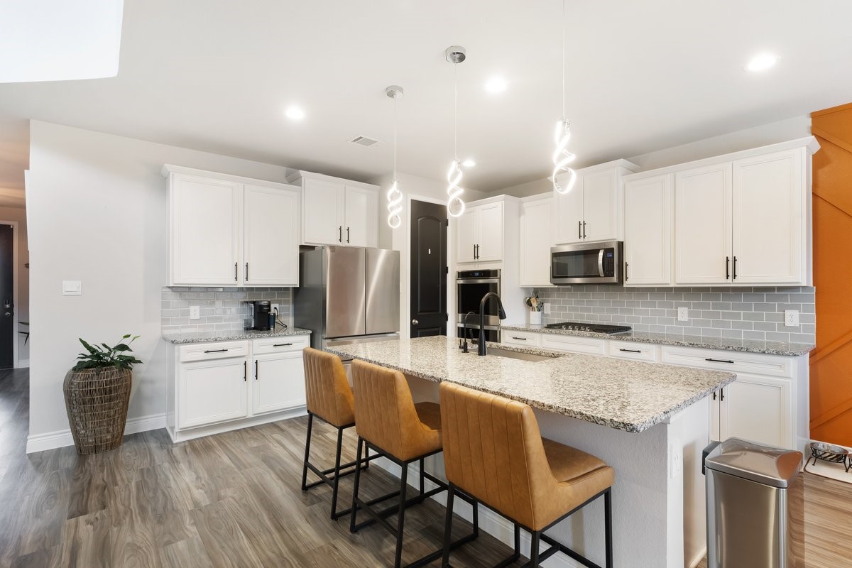 15815 Gibson Grass Court Spring, TX 77379 - Photo 8 of 25 a kitchen with refrigerator a stove and chairs