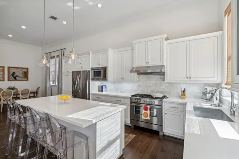 a kitchen that has a lot of cabinets a sink and a stove in it