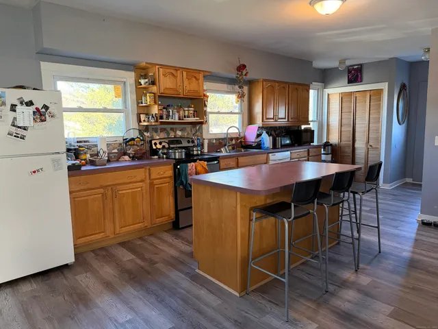a kitchen with wooden floors and white appliances
