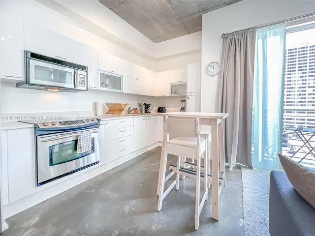 a living room with furniture a fireplace and a large window