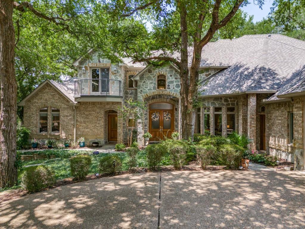 a front view of a house with trees and plants