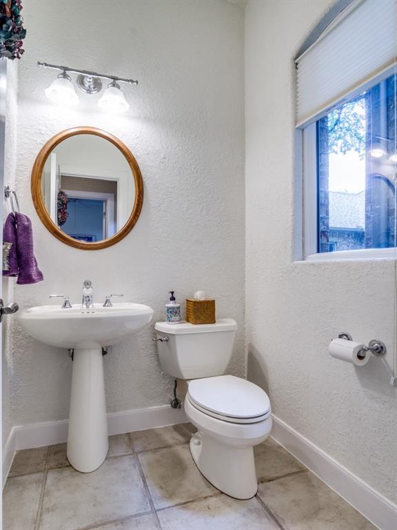 1014 Amanda Drive Mansfield, TX 76063 - Photo 23 of 40 a bathroom with a toilet a sink and a mirror