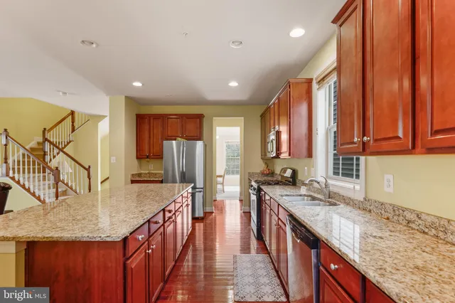 a kitchen with stainless steel appliances granite countertop refrigerator sink and cabinets
