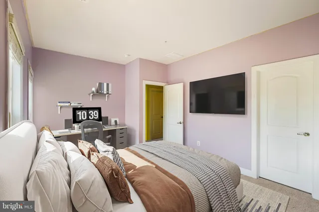 a bedroom with a bed and a painting on the wall