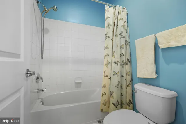 a white toilet sitting next to a shower