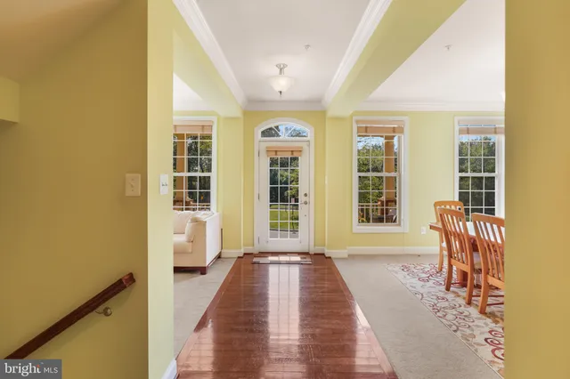 a living room with furniture a large window and wooden floor