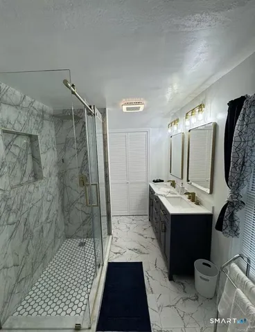 a bathroom with a sink a toilet and shower
