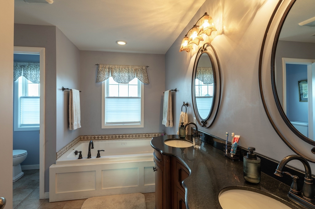 83 Bay Road Hadley, MA 01035 - Photo 17 of 36 a bathroom with a granite countertop toilet a sink and a mirror