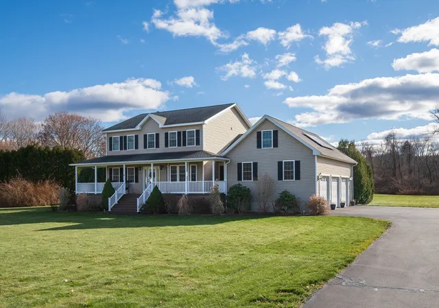 a front view of a house with garden and trees