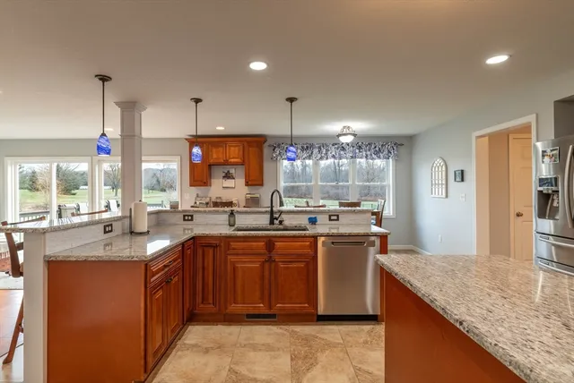 a kitchen with stainless steel appliances granite countertop a sink a stove and a refrigerator