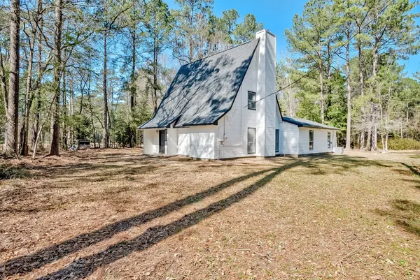a view of a house with large trees and covered with snow
