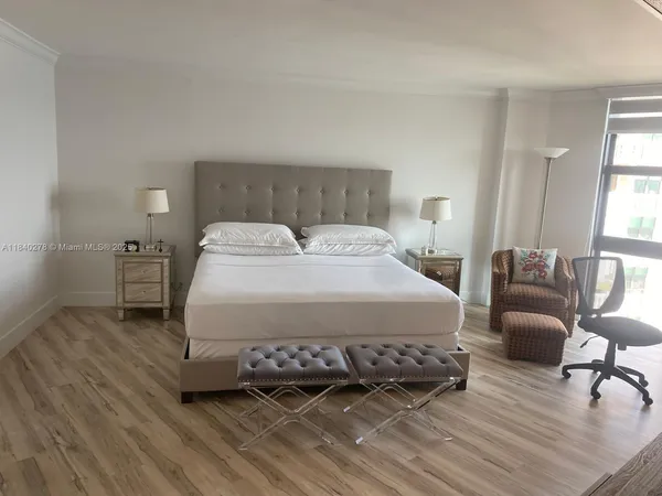 a spacious bedroom with a bed a couch and a window