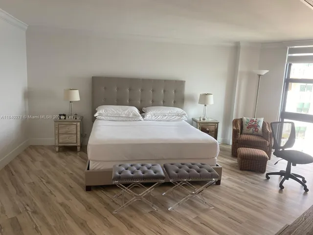 a spacious bedroom with a bed a couch and a window