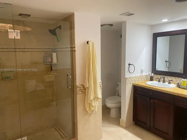a bathroom with a double vanity sink toilet and shower