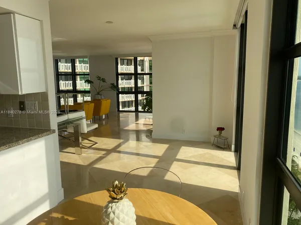 a living room with a table chairs and a flat screen tv