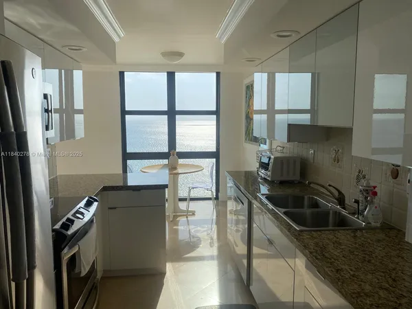 a kitchen that has a sink stainless steel appliances a counter space and a window