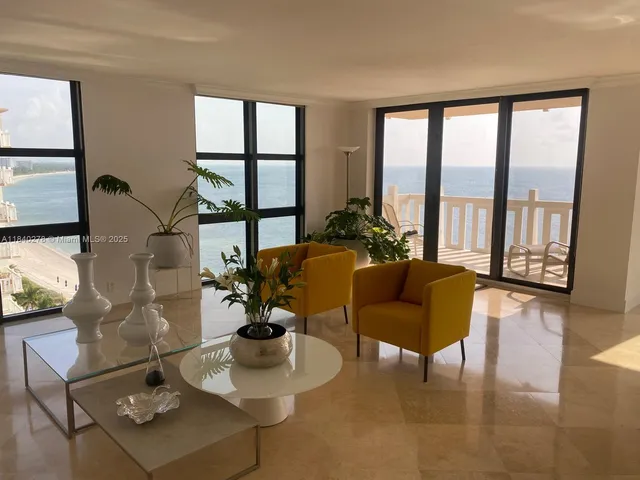 a living room with furniture and floor to ceiling windows