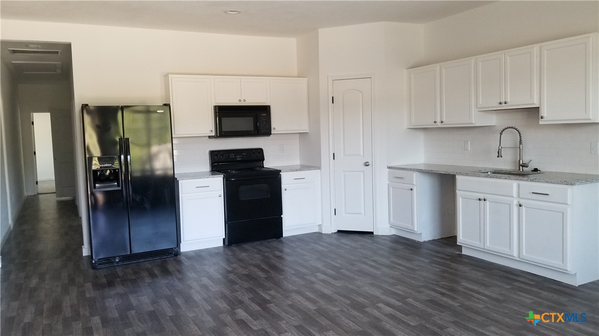 1063 Sleepy Hollow Lane Spring Branch, TX 78070 - Photo 2 of 14 a kitchen with a refrigerator sink and cabinets