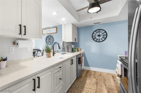 a view of a kitchen with a sink and a clock on the wall