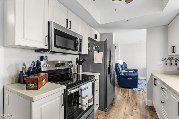 a kitchen with stainless steel appliances a stove a microwave refrigerator and cabinets