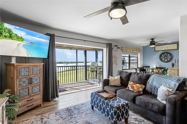 a living room with furniture a floor to ceiling window and a flat screen tv