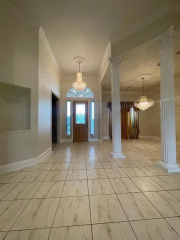 a view of a hallway with wooden floor and chandelier