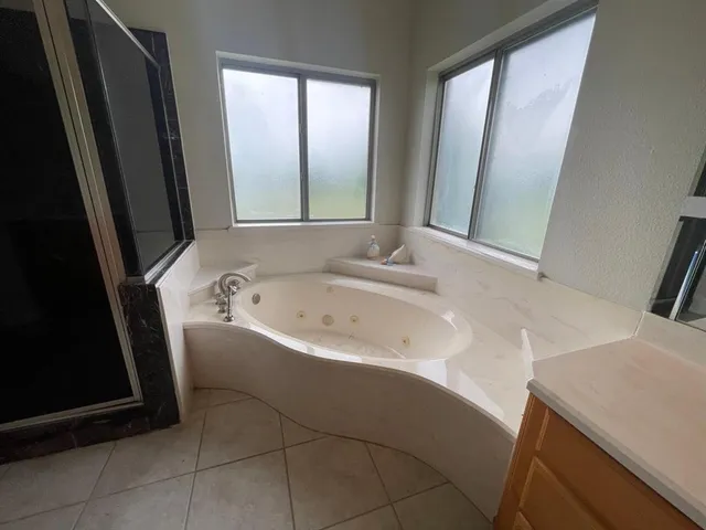 a large bathroom with a sink mirror vanity and bathtub