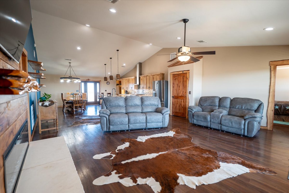1825 Savanna Ridge Ranch Road Lometa, TX 76853 - Photo 5 of 35 Living room featuring dark wood-style flooring, recessed lighting, a ceiling fan, high vaulted ceiling, and a tile fireplace
