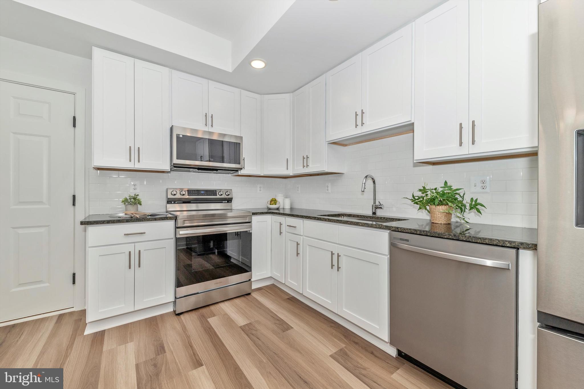 720 Iron Frg Road Frederick, MD 21702 - Photo 11 of 33 a kitchen with granite countertop white cabinets and white appliances