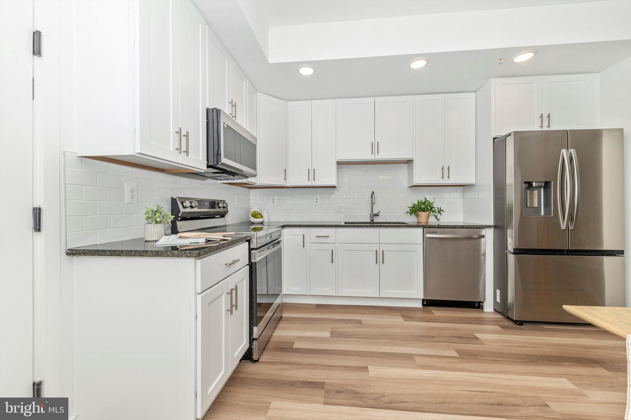 720 Iron Frg Road Frederick, MD 21702 - Photo 12 of 33 a kitchen with stainless steel appliances granite countertop a refrigerator sink and white cabinets