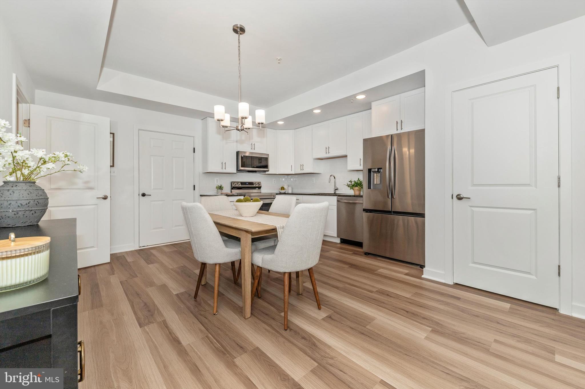 720 Iron Frg Road Frederick, MD 21702 - Photo 10 of 33 a kitchen with stainless steel appliances a dining table chairs and wooden floor