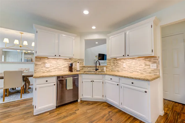 a kitchen with granite countertop white cabinets and white appliances