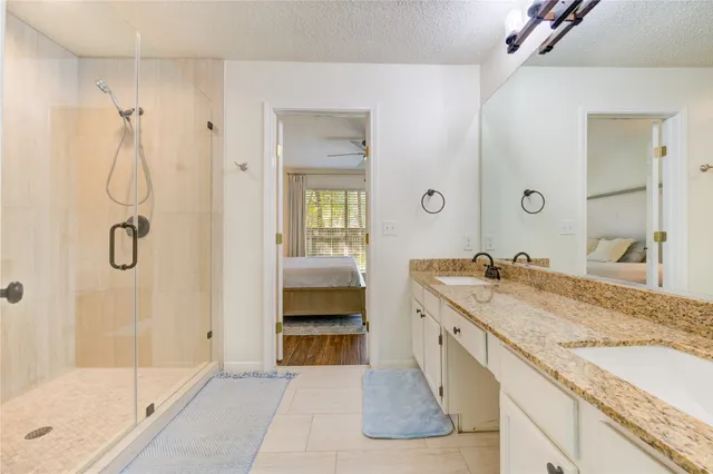a spacious bathroom with a granite countertop sink mirror and a bath tub