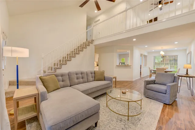 a living room with furniture and a wooden floor