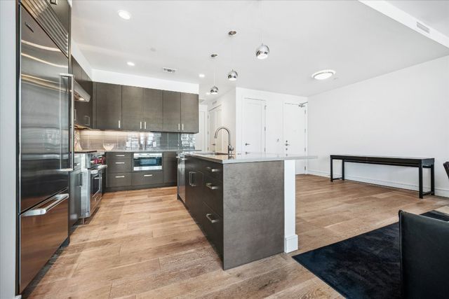 a kitchen with stainless steel appliances granite countertop a sink a stove and a refrigerator