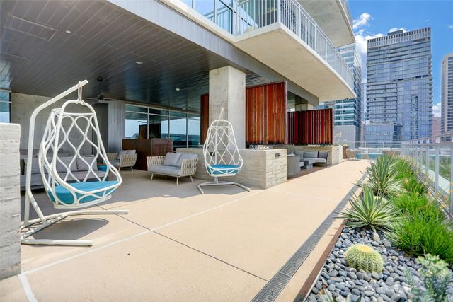 a kitchen with stainless steel appliances kitchen island granite countertop a table chairs in it and wooden floors