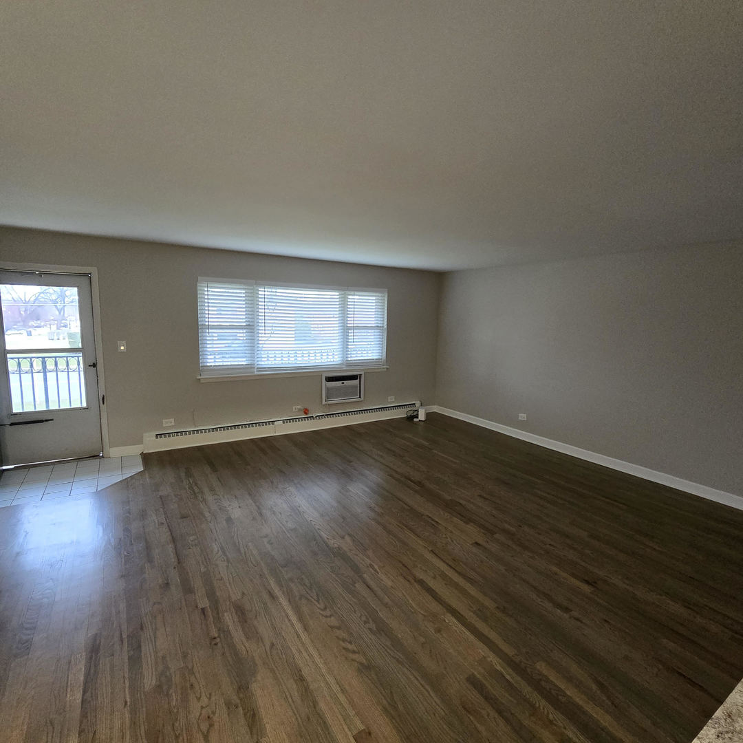 1817 West Touhy Avenue, Unit 2D Park Ridge, IL 60068 - Photo 6 of 7 an empty room with wooden floor and windows