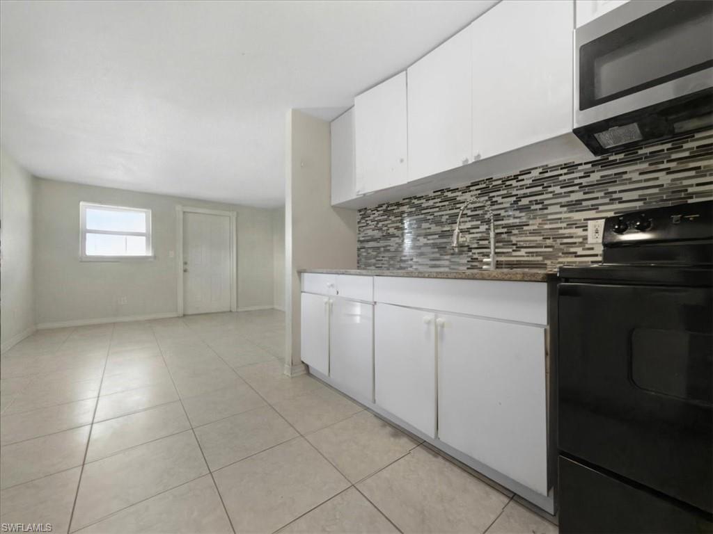 2495 Bayside Street Naples, FL 34112 - Photo 12 of 36 a kitchen with a sink and cabinets