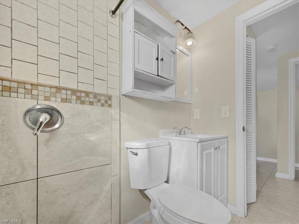 2495 Bayside Street Naples, FL 34112 - Photo 21 of 36 a bathroom with a toilet a sink and mirror