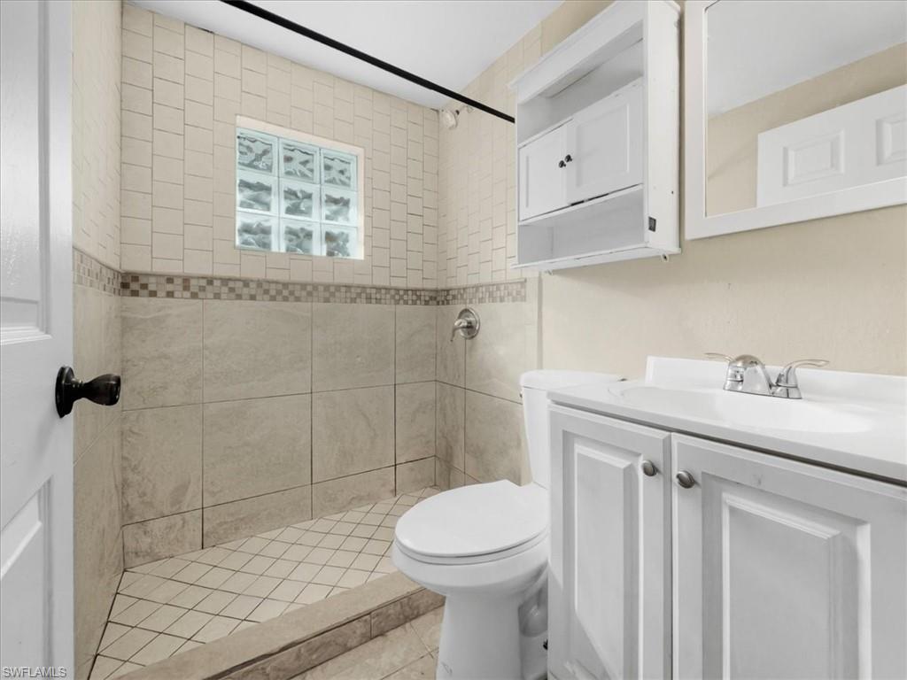 2495 Bayside Street Naples, FL 34112 - Photo 22 of 36 a bathroom with a sink a toilet and shower