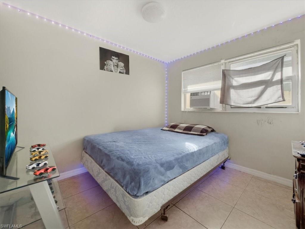 2495 Bayside Street Naples, FL 34112 - Photo 24 of 36 a bed sitting in a bedroom next to a window