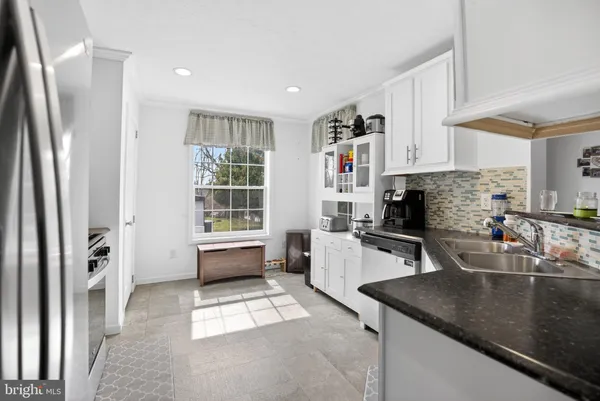 a kitchen with stainless steel appliances granite countertop a sink a stove and a refrigerator