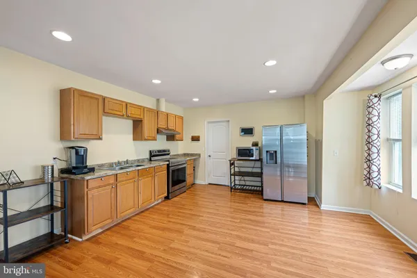 a kitchen with stainless steel appliances granite countertop a refrigerator and a stove top oven