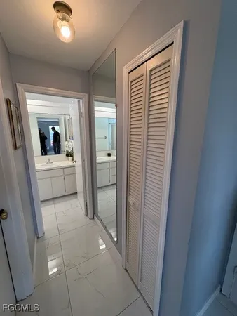 a view of a hallway with wooden floor and a bathroom