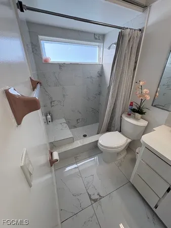a bathroom with a sink a toilet a mirror and shower