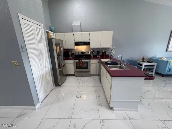 a kitchen with stainless steel appliances granite countertop a refrigerator and a stove