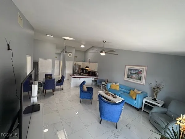 a living room with furniture and kitchen view