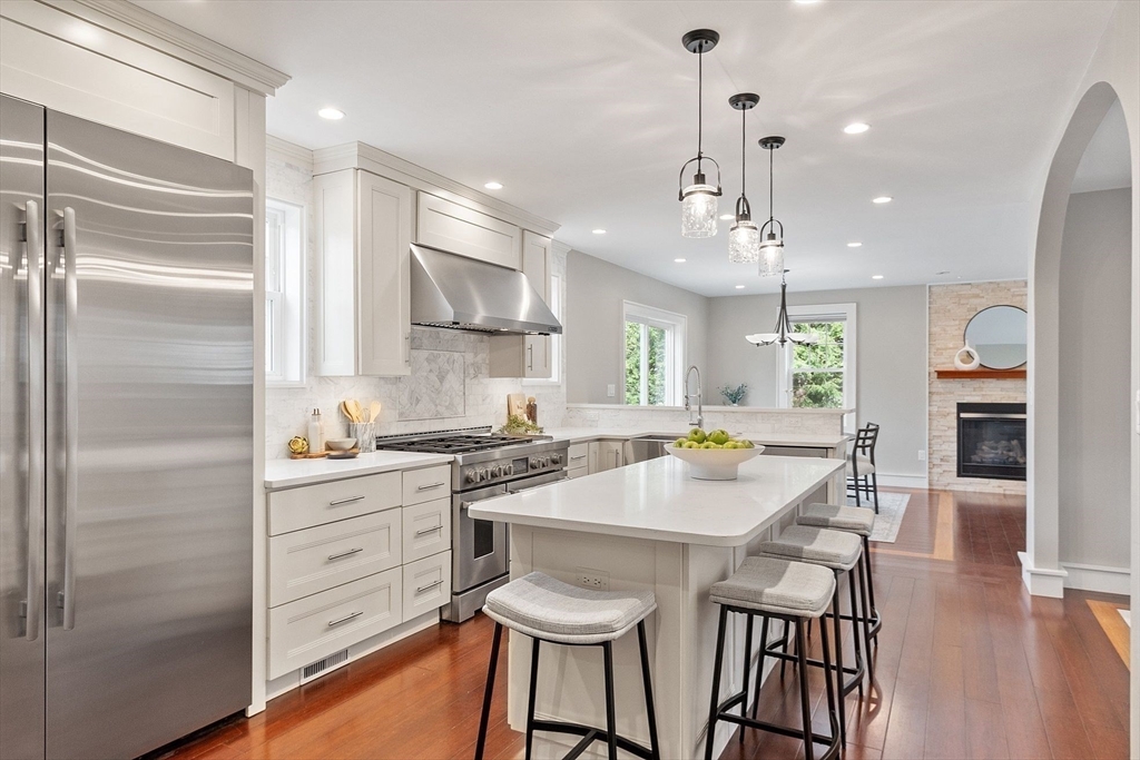 1 Pine Grove Road Medfield, MA 02052 - Photo 15 of 36 a kitchen with stainless steel appliances kitchen island granite countertop a refrigerator a stove a dining table and chairs with wooden floor