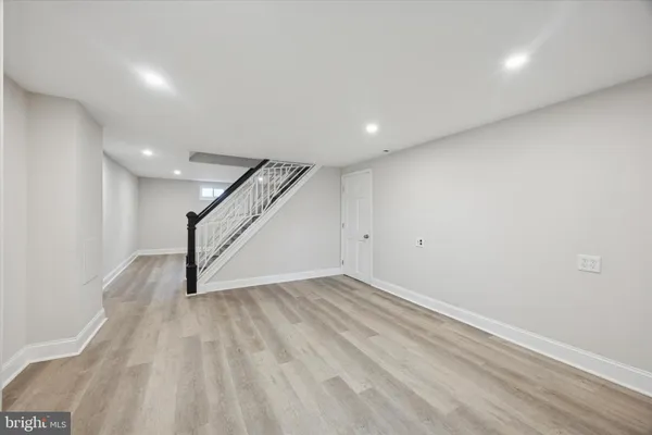 an empty room with wooden floor and staircase